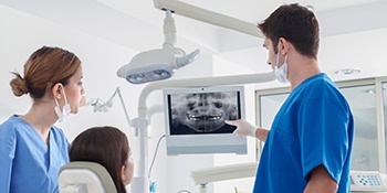 dentist showing his patient their dental x-rays 