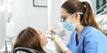 dental hygienist performing dental cleaning