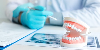 a dentist showing a patient how dentures can restore their smile