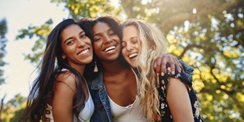 friends smiling in a park with metal-free restorations in Allentown