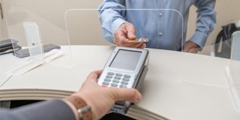 An adult man using a credit card to pay the cost of cosmetic dentistry
