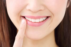 young woman smiling pointing at teeth