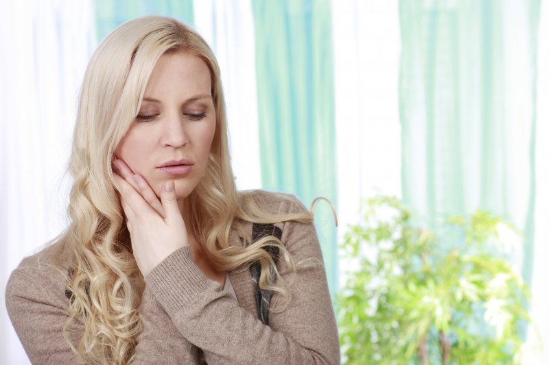 vrouw die pijn in haar kaak heeft