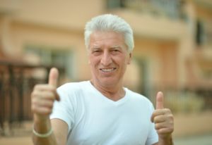 older happy man with her dental implants