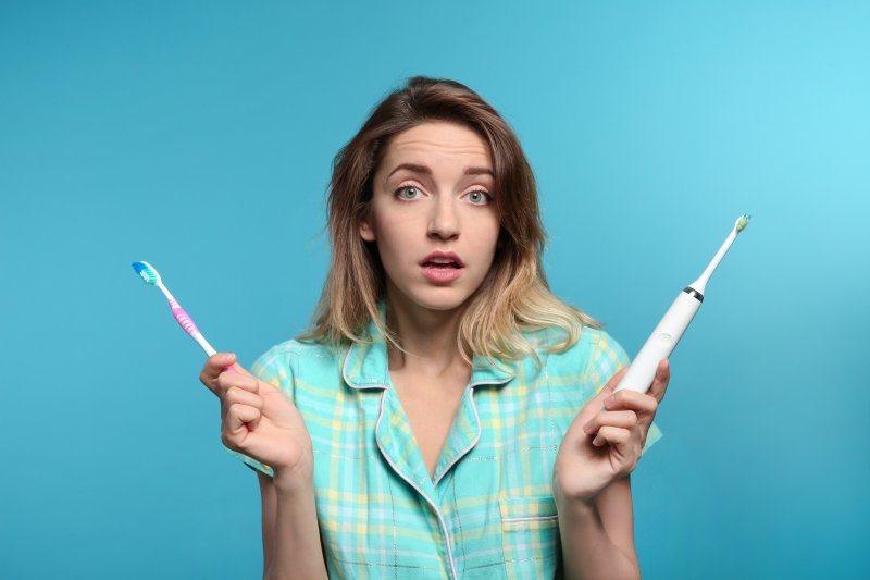 woman holding toothbrushes