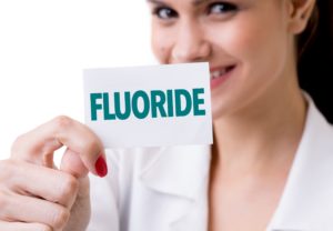 Dentist holding a fluoride card