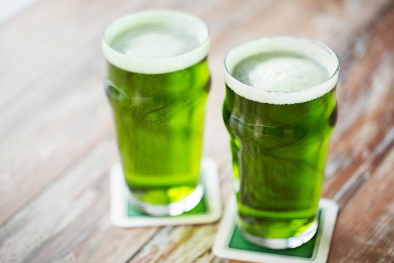 two green beers sitting on a table