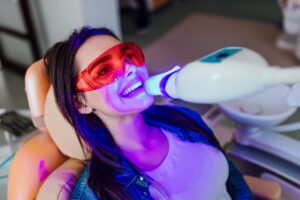 Woman having her teeth whitened at dentist.